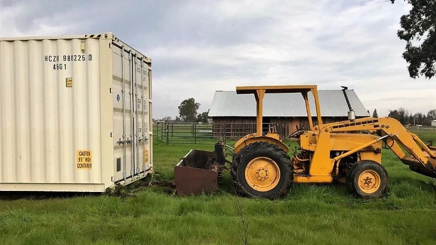 shipping container next to an agricultural tractor